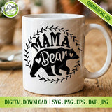 A close-up lifestyle mockup of a white ceramic coffee mug featuring the "MAMA BEAR" SVG design with a bear silhouette and laurel wreath