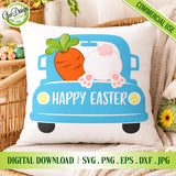 A square white throw pillow sitting on a wicker chair, featuring the printed vintage blue truck loaded with a carrot and bunny rear end design; cozy Easter decor background with tulips and a rabbit figurine