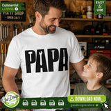A heartwarming lifestyle shot of a dad wearing a DIY PAPA tool shirt smiling at his son. An ideal digital design for crafters looking to make personalized family gifts, iron-on transfers, and sublimation shirts.