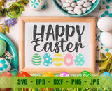 Flat lay wooden frame sign mockup on a white surface, displaying the "Happy Easter" with patterned eggs design inside, surrounded by colorful speckled Easter eggs and pussy willow