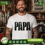 A professional male model in a woodworking workshop wearing a white t-shirt with a black PAPA tool design. This high-quality SVG and PNG file is perfect for creating custom Father's Day apparel and DIY handyman gifts.